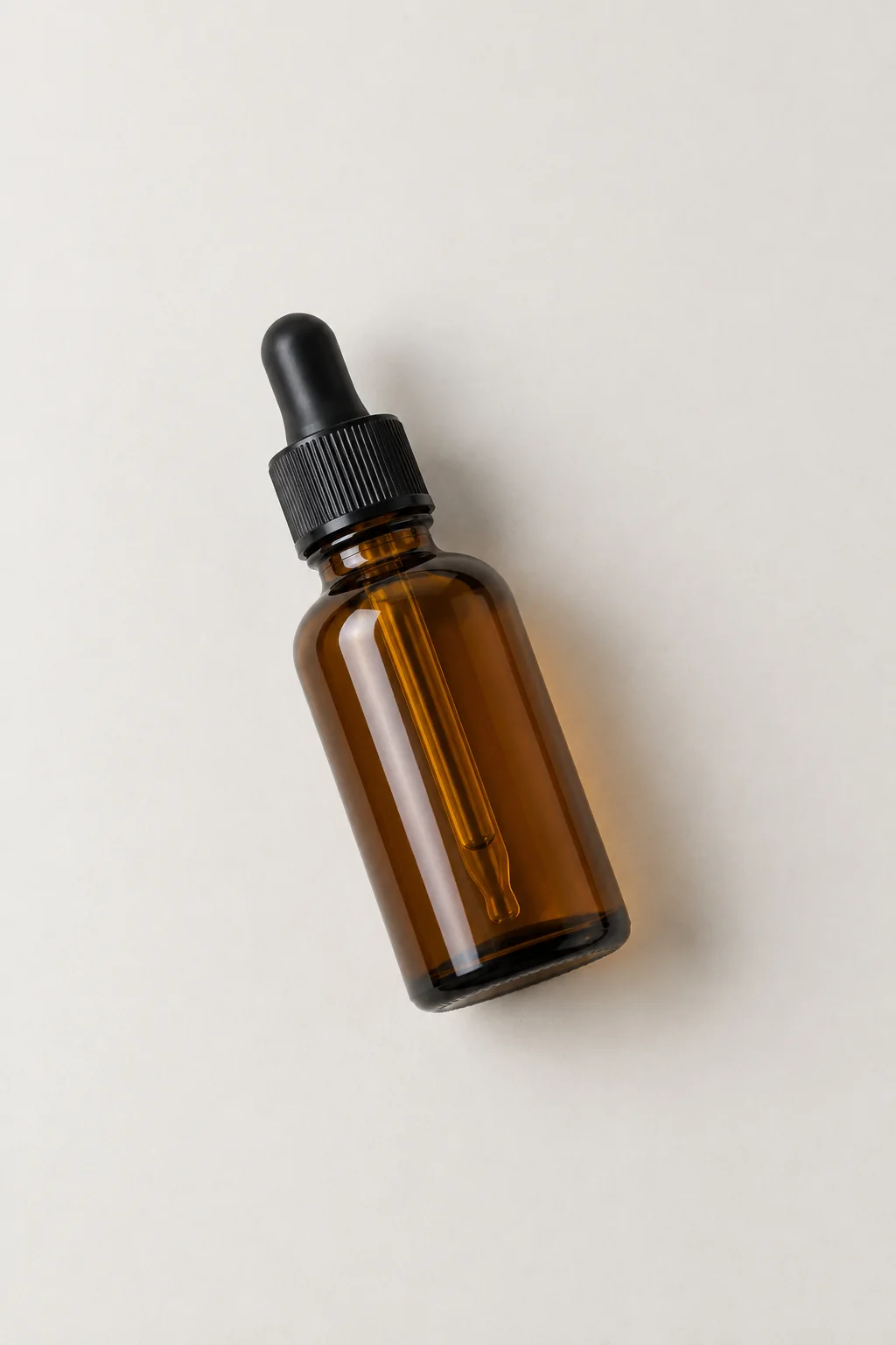 Amber dropper bottle lying on a pale tabletop