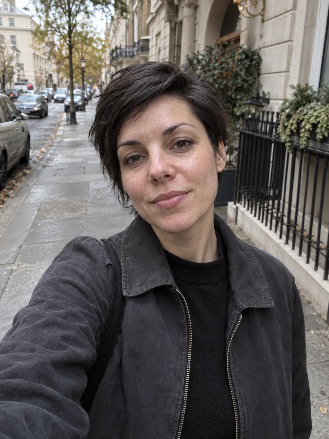 Woman taking a natural selfie on a city street